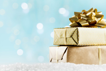 Golden gifts or presents boxes on magic bokeh background. Holiday composition for Christmas or New...