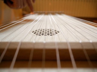 Sound healing therapy instrument Monochord, close up, with man hand playing on it.