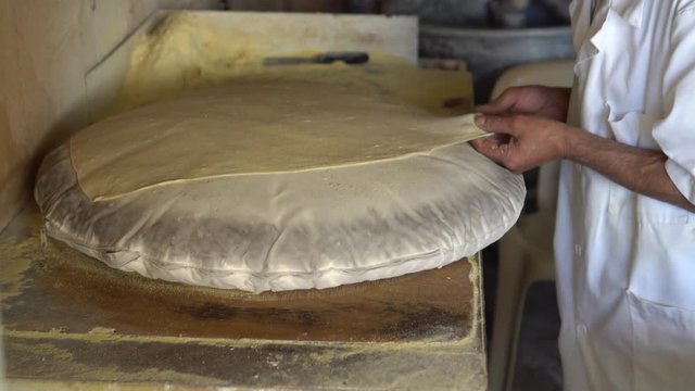 Making fresh markouk (mar2ou2) bread on Saj (iron covered fire)