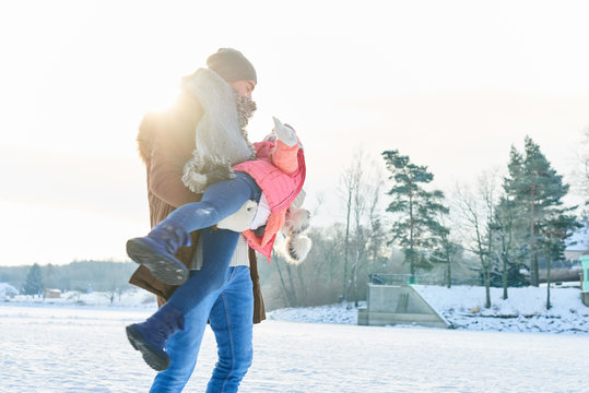 Vater tobt mit seiner Tochter im Winter