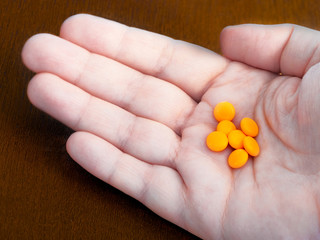 Orange pills on the palm of your hand