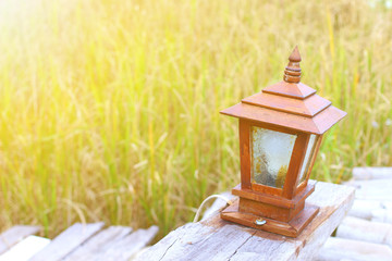 antique wooden lamp on the wood floor with blur green rice field background in vintage style concept of decorating 