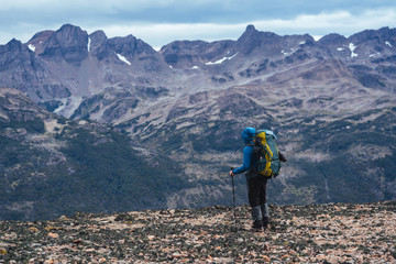 One man backpacker stands in front of mountains of Patagonia