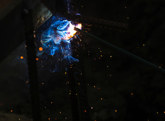 Flame of fire and sparks from welding metal at night