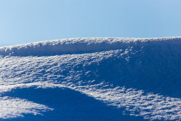 White snow against the blue sky as a background