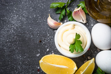 Mayonnaise sauce on black stone table. 