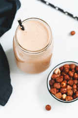 Nut butter chocolate protein shake in a glass jar. The concept of a healthy lifestyle and fitness diet.