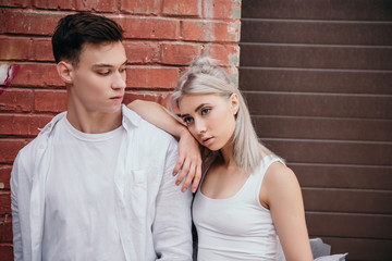 young couple of ballet dancers standing together near brick wall