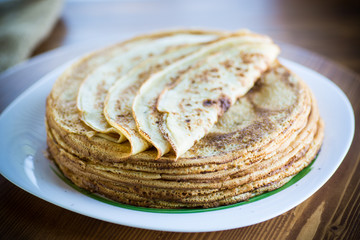 big high stack of thin pancakes in a plate