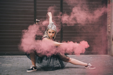 beautiful girl dancing in pink smoke and looking at camera on street © LIGHTFIELD STUDIOS