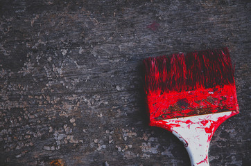 The brush is red on the wooden floor.The wooden floor has a brush on it.Do not focus on objects.