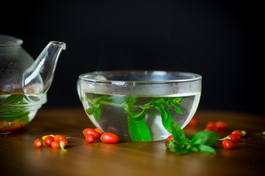 hot tea from ripe red goji berries in a glass teapot