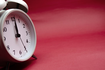 Close up.White Alarm Clock isolated Placed on a red background.copy space.