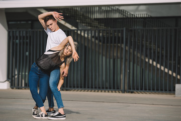 Fototapeta na wymiar young couple of dancers practicing on urban city street