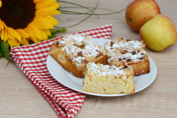 apple cake, sunflower  and apples on table