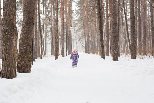 Childhood and nature concept - Adorable child playing in winter park