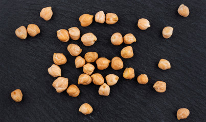 Heap of chickpea on black background, top view