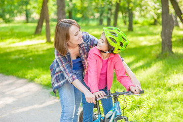 mother and daughter learning to ride a bicycle