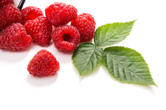 White cup with ripe raspberries and green leaf isolated on white background. - Powered by Adobe