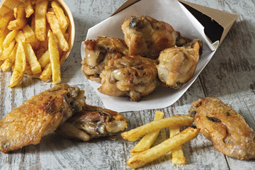 ali di pollo arrosto con patatine fritte fronte primo piano