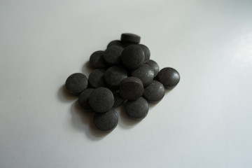 Black pills of chelated iron in a heap