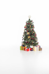 close up view of festive christmas tree and wrapped gifts isolated on white