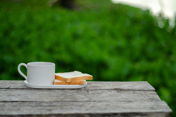 Breakfast set on wooden floor in the morning. Breakfast with coffee and bread.Do not focus on objects.