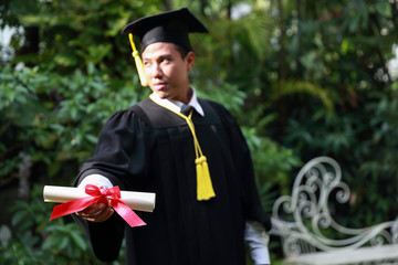 Happy man graduated holding and showing degree, idea for education concept