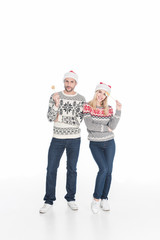 caucasian couple in santa claus hats with lollipops isolated on white