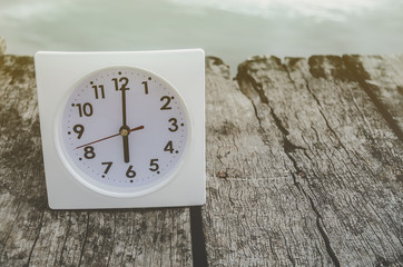 White clock on wooden floor river in the morning.On the river at 6:00 pm, there is a white clock on the wooden floor.