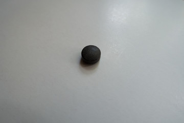 Single round black pill of chelated iron