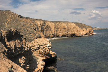 Sea and steep rugged cliffs. Coast of Crimea. Travel Lifestyle concept outdoor. 