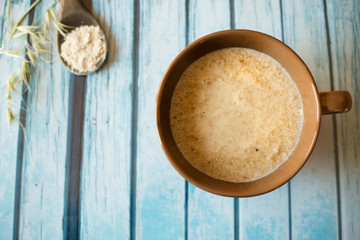 oat porridge bowl and spoon on a natural wooden background