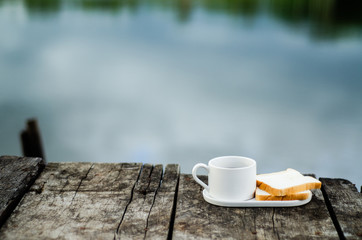 Breakfast set on wooden floor in the morning. Breakfast with coffee and bread.Do not focus on objects.