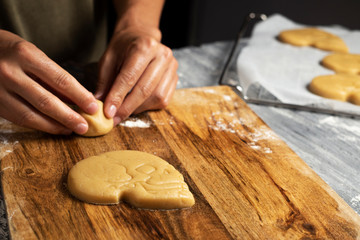 Hands of man preparing skull-shaped cookies