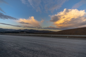 Clouds lit by the sunset sun with a dusty road in the foreground in the Gordon area, Leon (Spain).