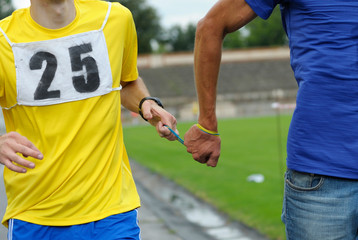 Way of leading blind runner: hand of disabled blind athlete (left) holds a hand of healthy one by...