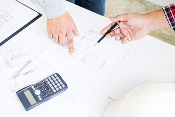 Close-up Of Person's engineer Hand Drawing Plan On Blue Print with architect equipment, Architects discussing at the table, team work and work flow construction concept