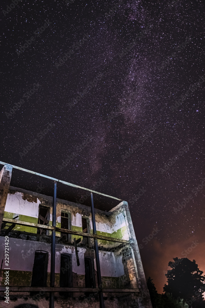 Wall mural night sky and the milky way over the old abandoned house