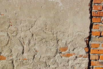 surface of an old wall with cement plaster red brick grunge background texture