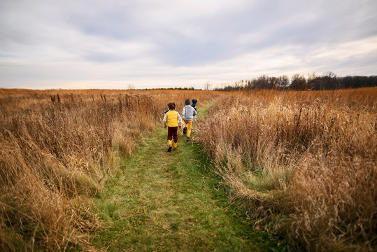 Three children running in a field, United States