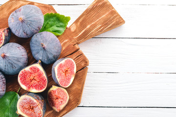 Fig. Fresh fruits of figs on a white wooden table. Free space for text. Top view.