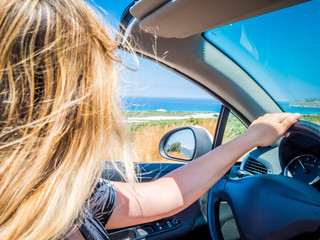 Crete, Greece: Blonde beautyful girl driving to Falassarna beach on the northwest of Chania...