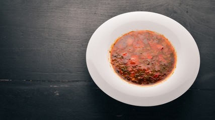 Vegetable soup kharcho. On the old wooden background. Free space for text. Top view.