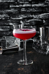 Alcohol cocktail with roses and rum. On a black wooden background. Free copy space. Top view.