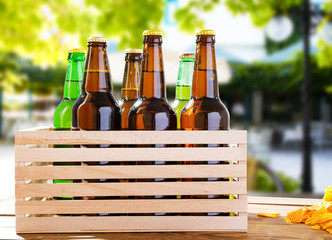 beer bottles on wooden table with blurred restaurant on background,coloured bottle, food and drink...