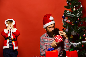 Man and boy in Santa hat play hide and seek