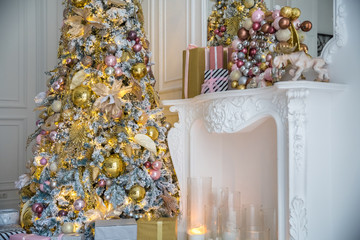 White room interior with New Year tree decorated, present boxes and fireplace