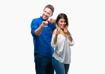 Young couple in love over isolated background pointing fingers to camera with happy and funny face. Good energy and vibes.