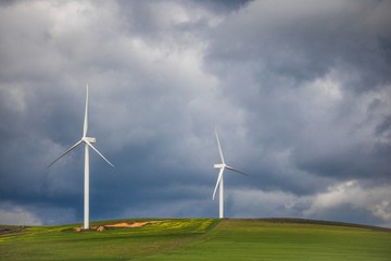 Dramatic thunderstorm over wind turbines in green fields - Caledon, Western Cape, South Africa.